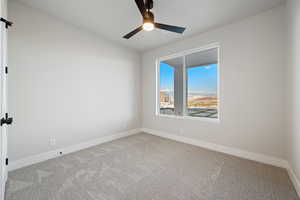 Unfurnished room with carpet floors and a ceiling fan