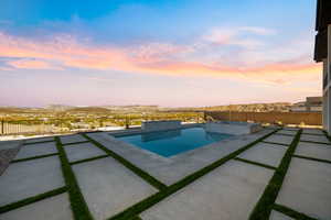 View of pool with a fenced backyard, a pool with connected hot tub, and a patio area