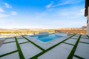 View of pool featuring a fenced backyard, a pool with connected hot tub, a patio area, and a mountain view