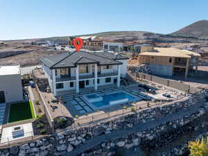 Rear view of property featuring a fenced backyard, a patio, a pool with connected hot tub, a residential view, and stairway