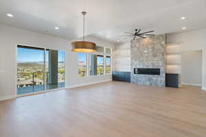 Unfurnished living room with a mountain view, built in features, a fireplace, light wood finished floors, and recessed lighting