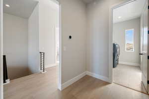 Hallway featuring recessed lighting, light wood finished floors, and an upstairs landing