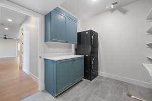 Laundry room with estacked washer and dryer, recessed lighting, ceiling fan, and cabinet space
