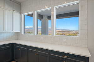Kitchen with light stone countertops, a mountain view, backsplash, and gray cabinetry
