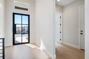 Doorway to outside with wood finished floors and recessed lighting