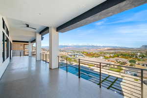 Balcony with a mountain view, a residential view, and a ceiling fan