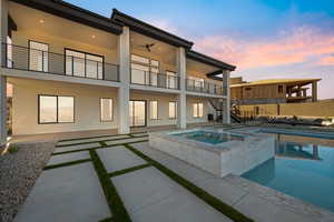Rear view of house with stairs, stucco siding, a patio area, and a pool with connected hot tub