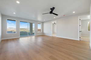 Spare room featuring light wood-style flooring, recessed lighting, a mountain view, and ceiling fan