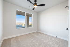 Carpeted empty room featuring baseboards and a ceiling fan