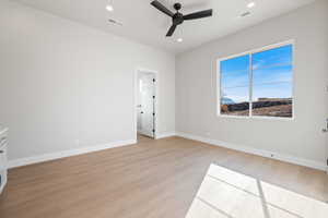 Spare room featuring light wood finished floors, a ceiling fan, and recessed lighting