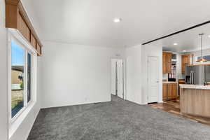 Unfurnished living room featuring dark colored carpet and recessed lighting