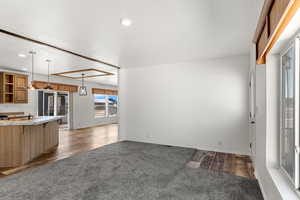 Unfurnished living room featuring recessed lighting, dark wood finished floors, and dark colored carpet