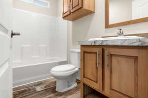 Bathroom featuring vanity, dark wood-type flooring, and shower / bath combination