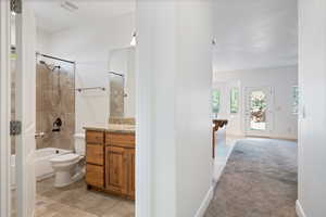 Bathroom with healthy amount of natural light, light tile patterned floors, vanity, and washtub / shower combination