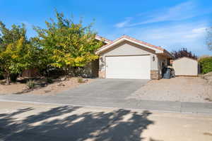 View of front of house featuring stone siding, stucco siding, driveway, a tiled roof, and an attached garage