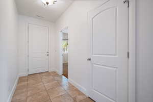 Doorway with tile patterned floors and baseboards
