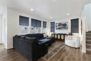 Living area featuring stairway, dark wood-type flooring, and recessed lighting