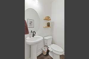 Bathroom featuring toilet and dark wood-style floors