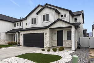 View of front of home with stone siding, a garage, board and batten siding, covered porch, and concrete driveway