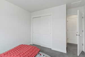 Bedroom featuring carpet flooring and a closet