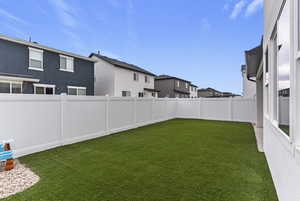 Fenced backyard featuring a residential view