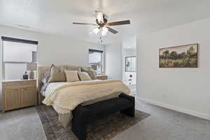 Bedroom with a textured ceiling, light carpet, and a ceiling fan