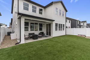 Rear view of house with a fenced backyard, stucco siding, a patio, and outdoor lounge area
