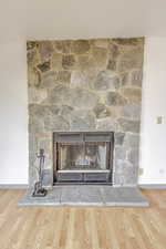 Detailed view of a stone fireplace and wood finished floors