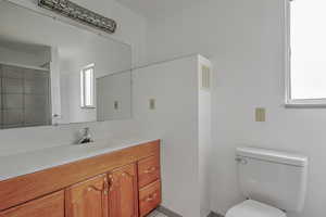 Bathroom with vanity, a shower stall, and healthy amount of natural light
