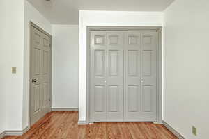 Unfurnished bedroom featuring light wood-style floors and a closet