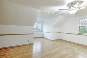 Additional living space featuring vaulted ceiling, light wood finished floors, and ceiling fan