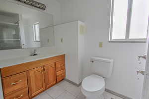 Bathroom with vanity, light tile patterned floors, and a shower with door