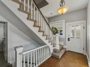 Entrance foyer featuring stairs and dark tile patterned floors