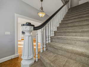 Stairs with tile patterned floors and baseboards
