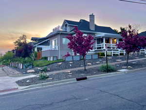 View of front of home featuring a chimney and covered porch