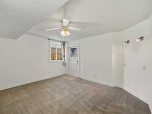 Carpeted empty room featuring a ceiling fan and baseboards