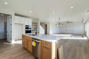 Kitchen featuring light wood-type flooring, recessed lighting, stainless steel appliances, open floor plan, and ceiling fan