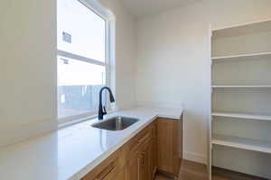 Kitchen featuring brown cabinets, light stone countertops, and dark wood-style flooring