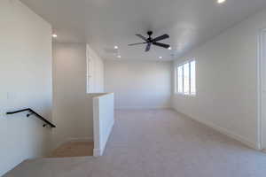 Empty room with light colored carpet, recessed lighting, and ceiling fan