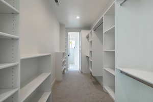 Spacious closet with light colored carpet