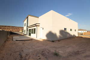 View of side of home with a fenced backyard and stucco siding