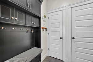 Mudroom featuring dark tile patterned flooring and baseboards