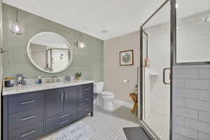 Full bathroom with vanity, a shower stall, and wooden walls