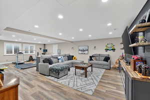 Living room with light wood-type flooring and recessed lighting
