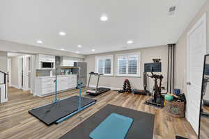 Workout room featuring light wood-style flooring and recessed lighting