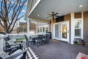 Wooden deck featuring outdoor dining area, ceiling fan, a trampoline, and grilling area