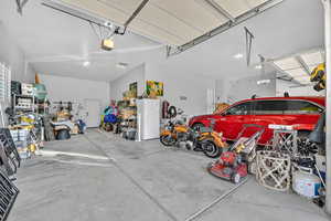 Garage featuring freestanding refrigerator and a garage door opener