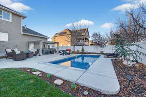View of swimming pool with an outdoor living space, a fenced backyard, a patio area, and a pergola