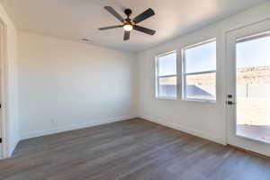 Empty room with dark wood-style floors and ceiling fan