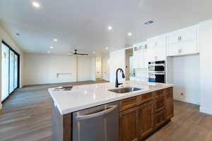 Kitchen with glass insert cabinets, stainless steel appliances, dark wood-type flooring, open floor plan, and brown cabinets